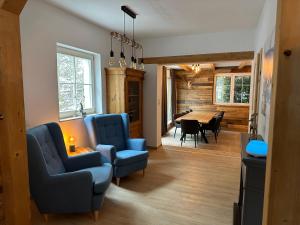 a living room with two blue chairs and a table at Chalet Ferienhaus Dresden in Dresden