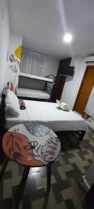 Habitación con 2 camas y una silla. en Hotel Habibi, en Barranquilla