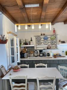 a kitchen with a white table and chairs in a room at villa ZEUS - PARIKIA - PAROS - GRECE in Krotiri