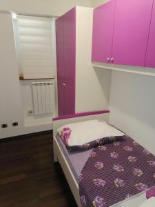 een kleine slaapkamer met paarse kasten en een bed bij Apartment Ena in Kukuljanovo
