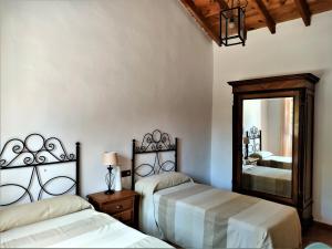 アリアテにあるCasa rural las Tablasのベッドルーム1室(ベッド2台、大きな鏡付)