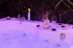 uma banheira cheia de copos de vinho e garrafas de vinho em AlbaDea Suites&Jacuzzi em Roma