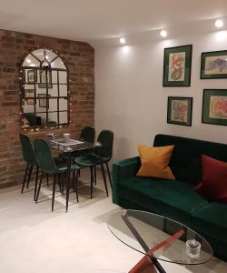 ein Wohnzimmer mit einem grünen Sofa und einem Tisch in der Unterkunft Avantgarde in Euskirchen