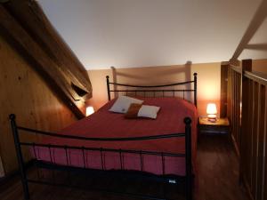 a bedroom with a red bed with two pillows at Maisonnette La Bienvenue in Trainel