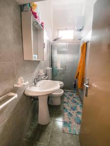 y baño con lavabo, aseo y ducha. en Villetta tra ulivi e mare, en Torre Suda