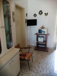 sala de estar con espejo y TV en Villetta tra ulivi e mare, en Torre Suda