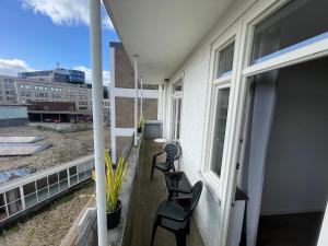 a balcony with two chairs and a window at Appartement Arnhem in Arnhem