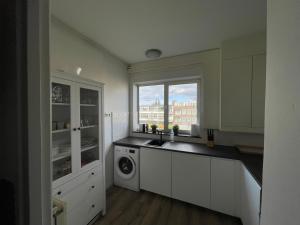 a kitchen with a sink and a washing machine at Topsleep Apartments 24-2 in Arnhem