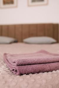 a pink towel laying on top of a bed at Apartman Stella in Bosanska Gradiška +5 photos
