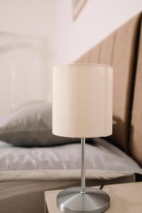 a lamp sitting on a table next to a bed at Apartman Stella in Bosanska Gradiška