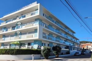 ein großes weißes Gebäude mit Balkon auf einer Straße in der Unterkunft Residência Bela Vida in São Martinho do Porto