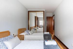 a bedroom with two beds and a mirror at PISO MODERNO COMPLETO LOVE MARIN 2 in Marín