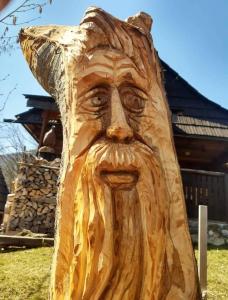a wooden statue of a man wearing a hat at Chata Evka in Ružomberok