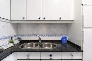 a kitchen with a sink and white cabinets at PISO MODERNO COMPLETO LOVE MARIN 2 in Marín