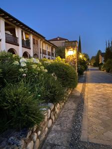 a cobblestone street with bushes and a building at Green Living Apartment in Pozzolengo