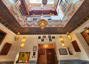 an ornate ceiling in a building with a chandelier at Riad Dar Kassim in Fez