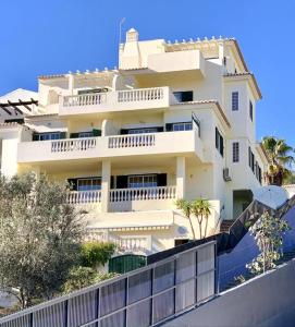 a large white building with a fence in front of it at Villa Hermano with views and private pool in Lagos