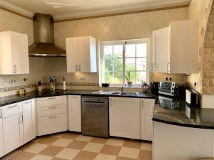a kitchen with white cabinets and a stainless steel appliance at Villa Hermano with views and private pool in Lagos