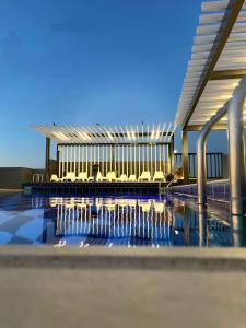 une piscine avec des chaises et un bâtiment dans l'établissement Mass Paradise Hotel, à Aqaba