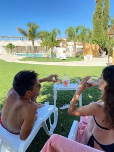 a man and a woman sitting at a picnic table at All`Ombra del Carrubo in Polignano a Mare