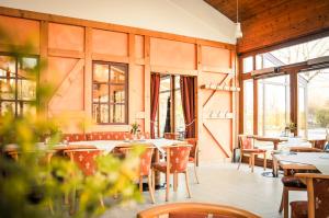 um restaurante com mesas, cadeiras e janelas em Schneiderlein Hotel em Limbach-Oberfrohna