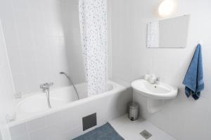 DREAM & RELAX Apartment في بوينج: حمام أبيض مع حوض ومغسلة ومرحاض