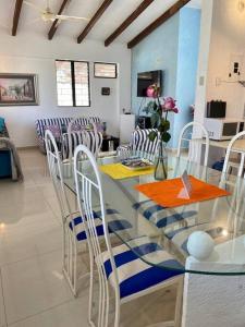 a dining room with a glass table and chairs at Casa Albatros (Playa-Esmeraldas) in Tonsupa