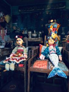 two dolls sitting on chairs in a room at Tainha da Praia Aparthotel in Bombinhas