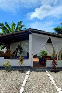 Casa blanca con pabellón con mesa en Casa Albatros (Playa-Esmeraldas) en Tonsupa