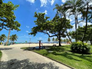 a park on the beach with palm trees and a sidewalk at Praia Gonzaga, Santos in Santos