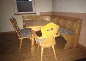 a wooden dining room table and chairs in a room at Ferienwohnung Zum Landsknecht in Lissendorf