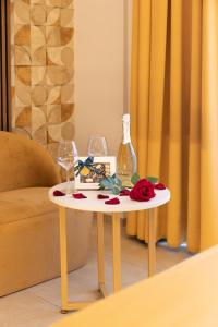 a table with two wine glasses and a bottle on it at AlbaDea Suites&Jacuzzi in Rome