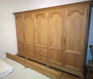 a wooden cabinet in the corner of a room at Ferienwohnung Zum Landsknecht in Lissendorf