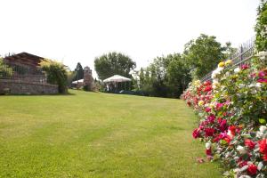 un jardín con flores rosas y una valla en Poggio Martino, en Cignano