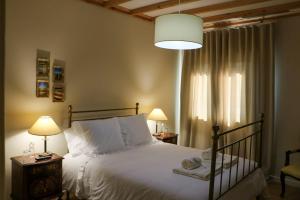 a bedroom with a bed and two lamps and a window at Eira da Fraga in Vila Nova de Foz Coa