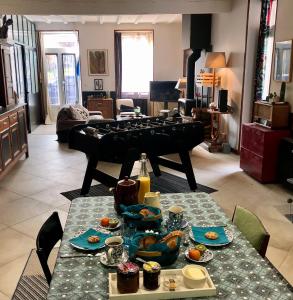 una sala de estar con una mesa con comida y un piano en Cookie home en Dolomieu