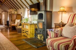 una sala de estar con estufa de leña. en Manor House Stables, Martin - lovely warm cosy accommodation near Woodhall Spa, en Martin