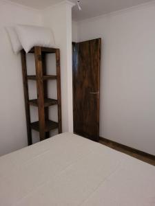 Un dormitorio con una cama y una puerta de madera. en Cabañas Iñ Püñen, en General Belgrano