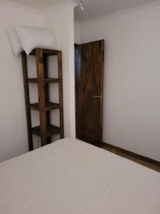 1 dormitorio con 1 cama y puerta de madera en Cabañas Iñ Püñen en 