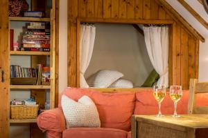 a living room with a couch and two glasses of wine at The Hayloft and Bothy at the Manor House Stables - TWO units in Martin near Woodhall Spa - Dogs Welcome! in Martin