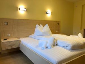 Vila Toscana في تيميشوارا: غرفة نوم بسرير كبير عليها شراشف ووسائد بيضاء