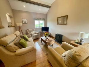 ein Wohnzimmer mit 2 Sofas und einem TV in der Unterkunft Fieldsview in Wrexham