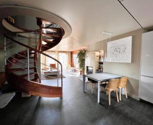 eine Wendeltreppe in einem Zimmer mit einem Tisch und Stühlen in der Unterkunft Apartament Nadbrzeżna de luxe in Mielno