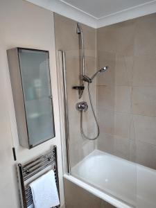 uma casa de banho com um chuveiro e uma banheira branca em Wentworth Drive Contractor and family 3 bed Home Grantham em Lincolnshire