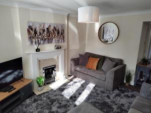 sala de estar con sofá y chimenea en Wentworth Drive Contractor and family 3 bed Home Grantham, en Lincolnshire