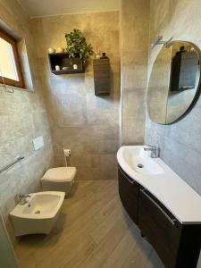 La salle de bains est pourvue d'un lavabo, de toilettes et d'un miroir. dans l'établissement Moderno trilocale a 20 metri dal mare, à San Vincenzo