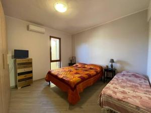 a bedroom with two beds and a dresser and a television at Moderno trilocale a 20 metri dal mare in San Vincenzo