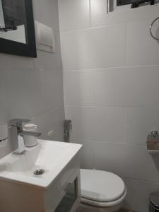 a white bathroom with a toilet and a sink at Beautiful studio in Palermo in Buenos Aires