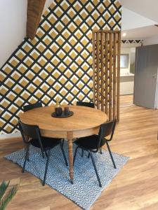 un tavolo con sedie in una stanza con una parete in legno di Le Studio Des Pervenches a Spa