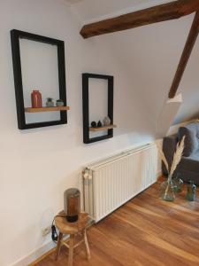a living room with a radiator and two mirrors at Le Studio Des Pervenches in Spa